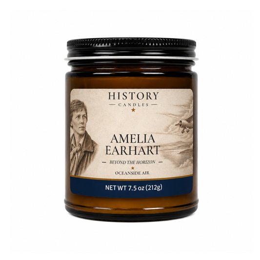 An amber glass jar candle with a black metal lid and a vintage-style label for 'History Candles' named 'Amelia Earhart', on a plain white background.