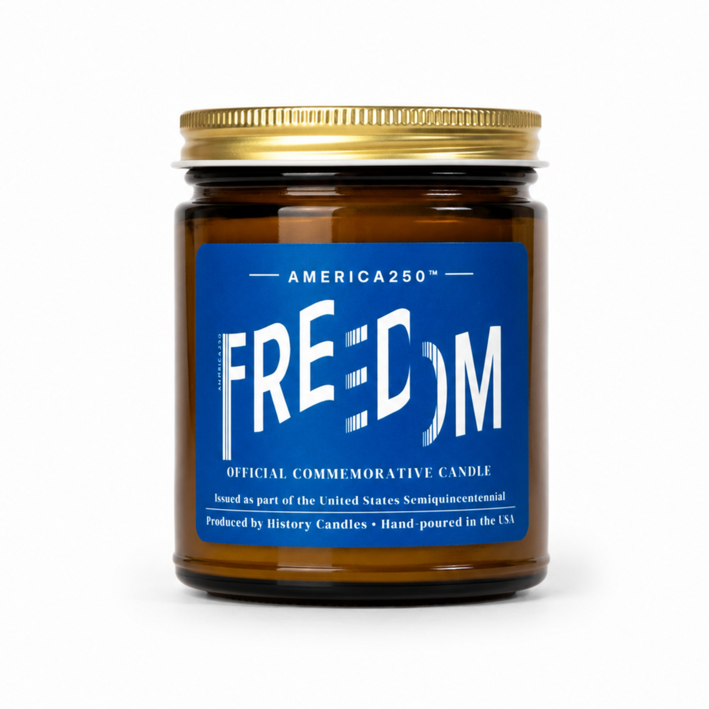 An amber glass jar candle with a gold metal lid and a blue label reading 'FREEDOM' and 'AMERICA250', photographed on a clean white background.