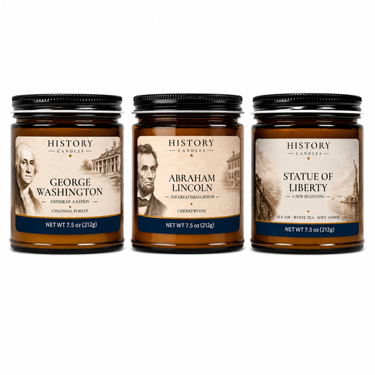Three amber glass jar candles with black metal lids are shown side by side on a white background. The labels read History Candles and feature George Washington, Abraham Lincoln, and Statue of Liberty scents.