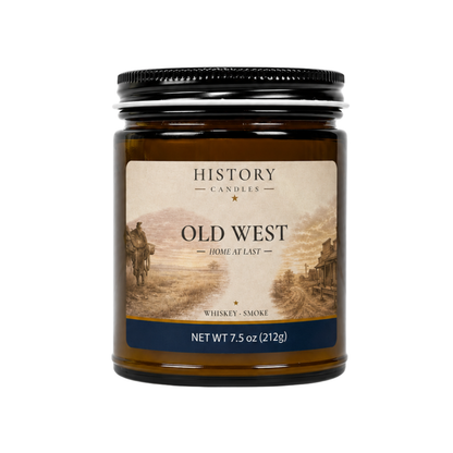 Old West candle in an amber glass jar with black lid, featuring Old West artwork and a Whiskey & Smoke fragrance.